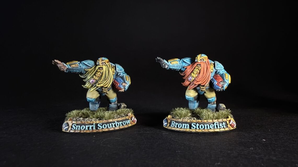 Two blue-armored dwarf miniatures with long beards stand on grassy bases, bases labeled Snorri Sourbrow and Brom Stonefist.