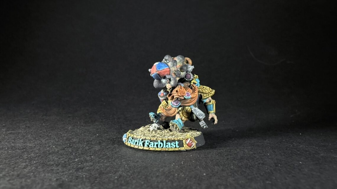 Miniature fantasy warrior figure, colorful armor, standing on rocky base with a banner reading Barik Farblast